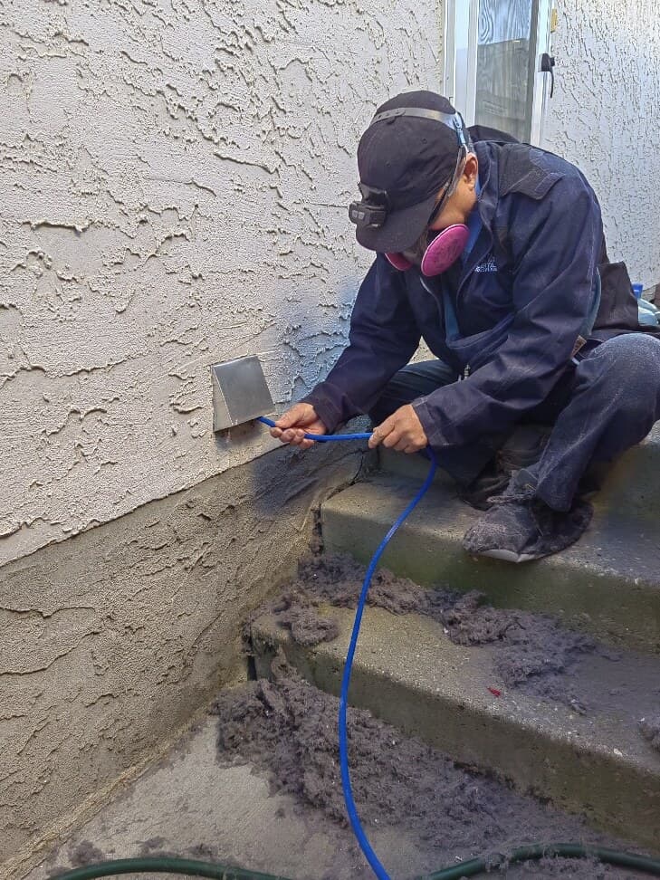 Technician cleaning an exterior dryer vent